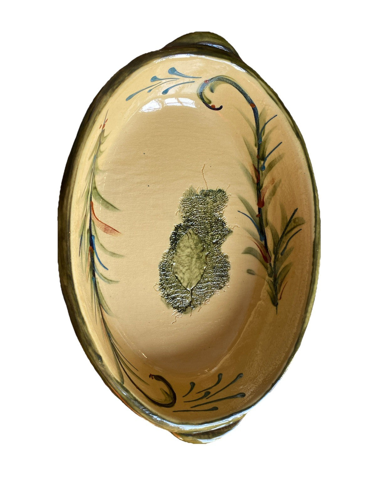 Plat ovale ancien en céramique avec décor végétal artisanal, mettant en valeur son style unique et élégant.