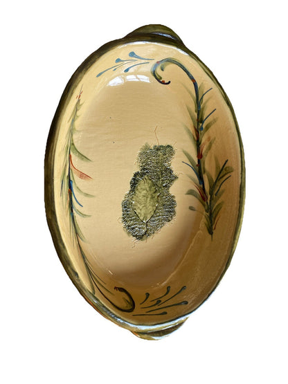 Plat ovale ancien en céramique avec décor végétal artisanal, mettant en valeur son style unique et élégant.