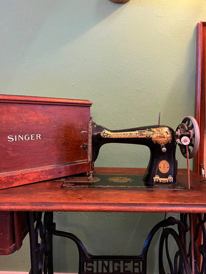 Machine à coudre Singer sur meuble à pédalier en fonte